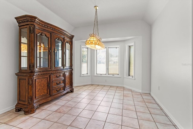 tiled dining space featuring vaulted ceiling