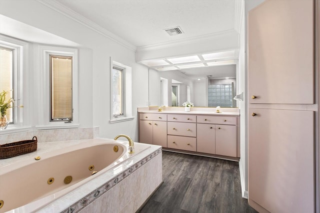 bathroom featuring tiled tub, hardwood / wood-style floors, plenty of natural light, vanity, and ornamental molding