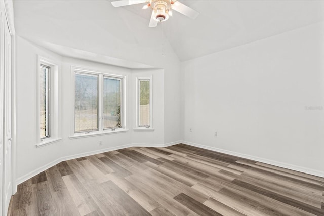 empty room with lofted ceiling, hardwood / wood-style floors, and ceiling fan