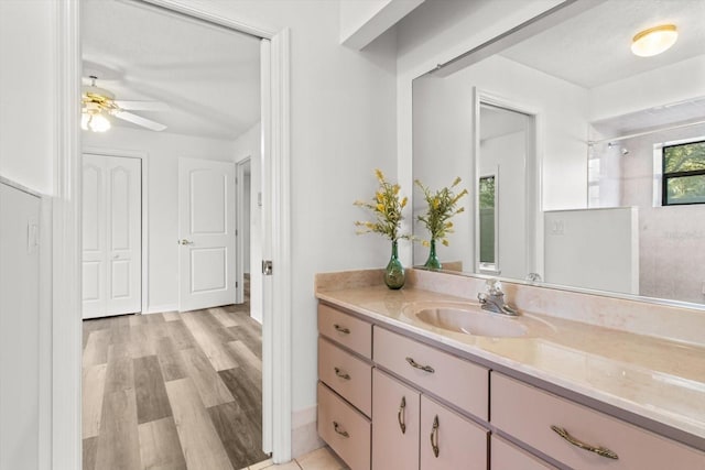 bathroom featuring hardwood / wood-style flooring, vanity, a shower, and ceiling fan