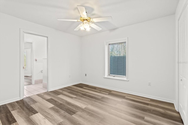 unfurnished bedroom with connected bathroom, light hardwood / wood-style flooring, and ceiling fan