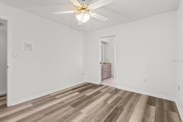 empty room with ceiling fan and light hardwood / wood-style flooring