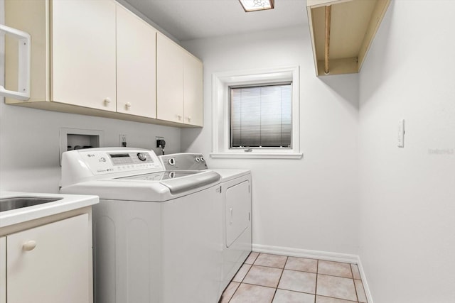 laundry room featuring light tile patterned flooring, cabinets, and separate washer and dryer