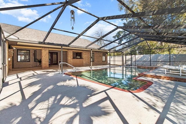 view of pool with glass enclosure and a patio area