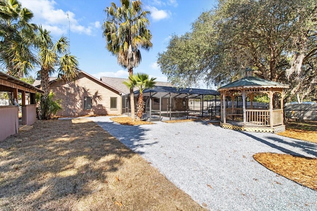 rear view of house with a gazebo and glass enclosure