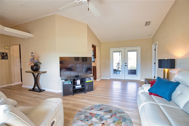 living room with french doors, ceiling fan, lofted ceiling, and light hardwood / wood-style floors