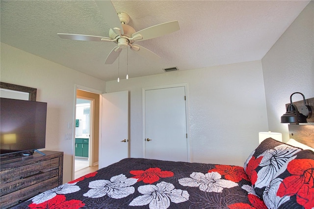 bedroom with ceiling fan and a textured ceiling