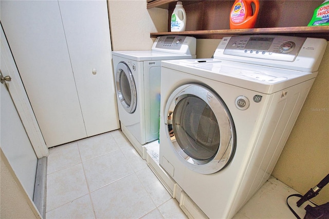 laundry room featuring light tile patterned flooring and washing machine and dryer