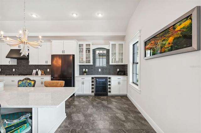 kitchen featuring black refrigerator, wine cooler, white cabinetry, and a breakfast bar