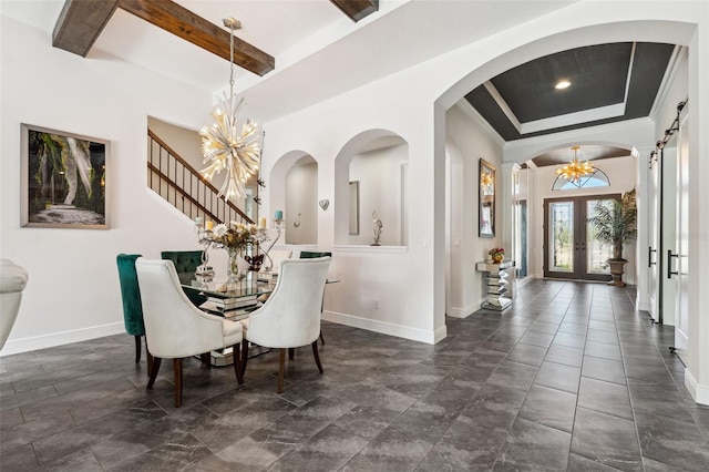 dining area featuring ornate columns, a notable chandelier, a tray ceiling, beam ceiling, and french doors