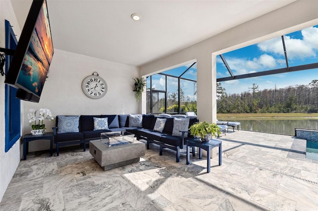 view of patio / terrace featuring a lanai, an outdoor living space with a fire pit, and a water view