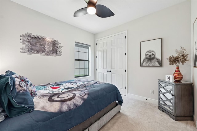 bedroom with ceiling fan, light colored carpet, and a closet