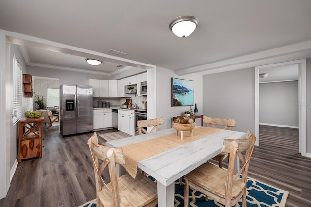 dining space featuring ornamental molding and dark hardwood / wood-style flooring