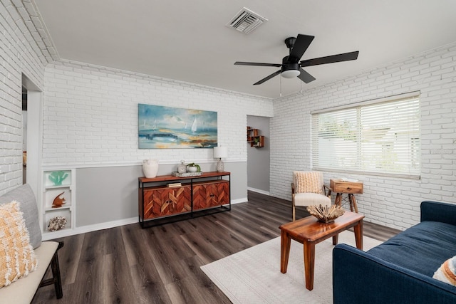 living room with ceiling fan, brick wall, and dark hardwood / wood-style flooring