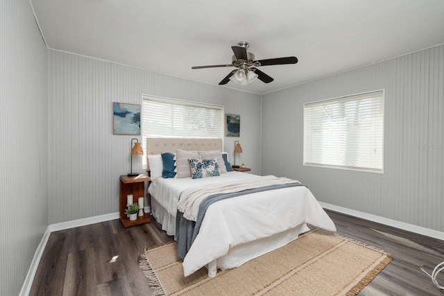 bedroom featuring multiple windows, dark wood-type flooring, and ceiling fan