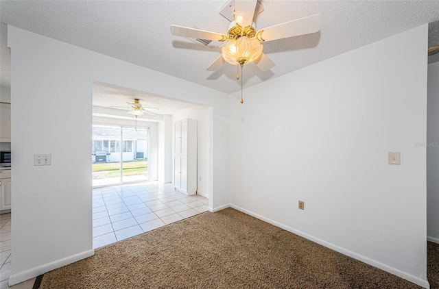 carpeted empty room featuring ceiling fan and a textured ceiling