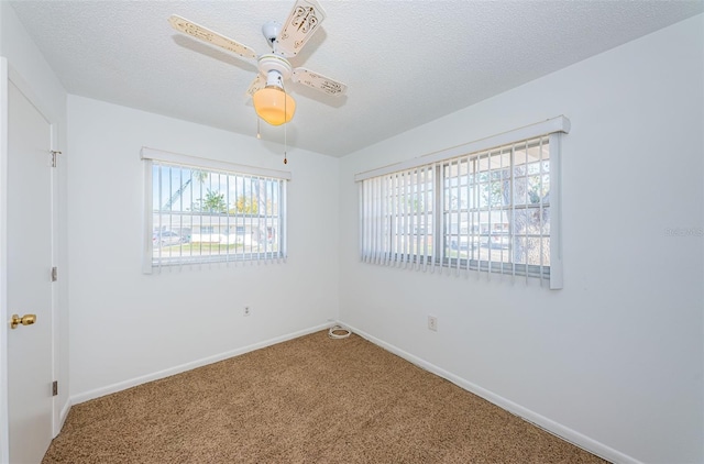 carpeted empty room featuring ceiling fan and a textured ceiling