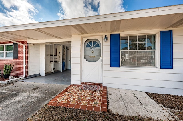 view of exterior entry with a carport