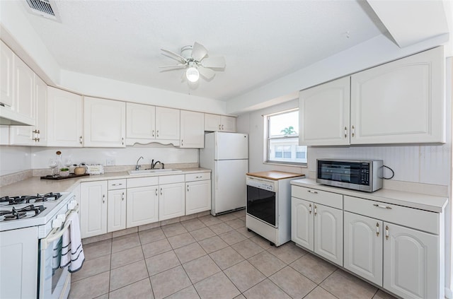 10022 Lily St N Unit N, Pinellas Park, FL 33782 - kitchen with white appliances, ceiling fan, white cabinetry, light countertops, and light tile patterned floors