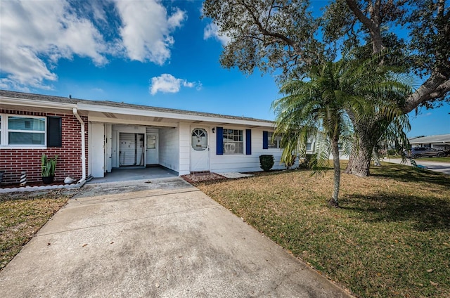 10022 Lily St N Unit N, Pinellas Park, FL 33782 - single story home with a front yard, concrete driveway, an attached carport, and brick siding