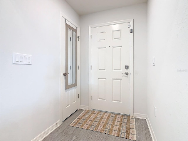 doorway to outside featuring wood finished floors and baseboards