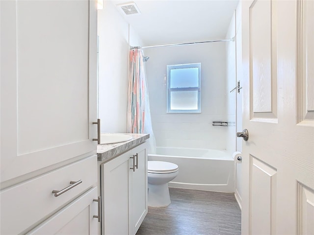 bathroom featuring visible vents, toilet, shower / bath combo, vanity, and wood finished floors