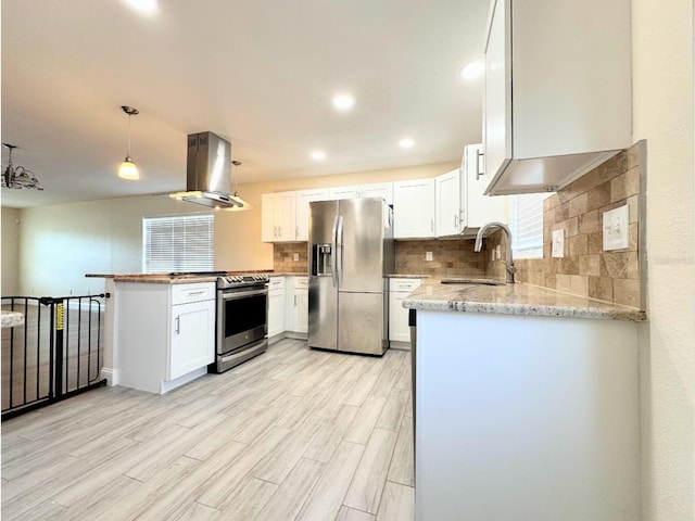 kitchen featuring sink, white cabinetry, island range hood, decorative light fixtures, and stainless steel appliances