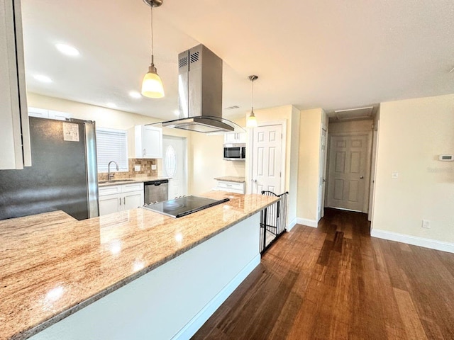 kitchen featuring white cabinetry, light stone counters, island range hood, hanging light fixtures, and stainless steel appliances