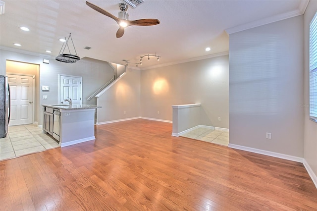 interior space with crown molding, sink, and light wood-type flooring