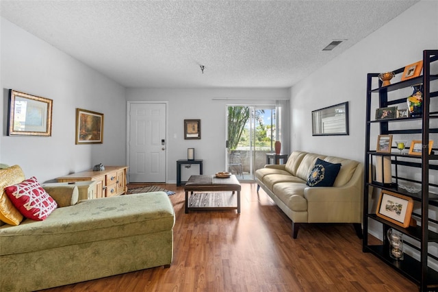 living room featuring dark wood-type flooring and a textured ceiling