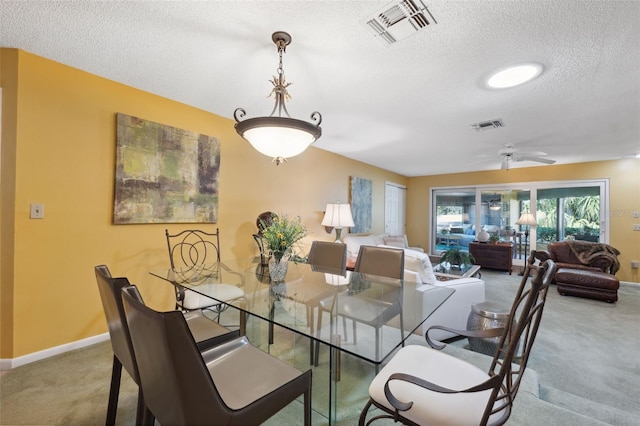 dining space featuring ceiling fan, carpet flooring, and a textured ceiling