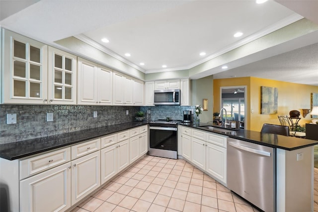 kitchen featuring stainless steel appliances, kitchen peninsula, sink, and white cabinets