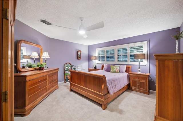 carpeted bedroom with ceiling fan and a textured ceiling