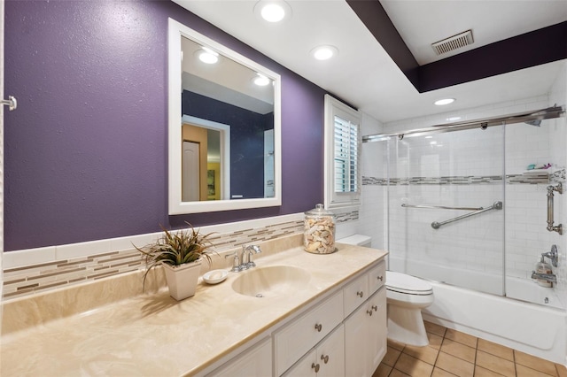 full bathroom featuring tasteful backsplash, tile patterned flooring, enclosed tub / shower combo, vanity, and toilet