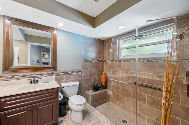 bathroom with a shower with shower door, tile walls, tile patterned flooring, vanity, and toilet