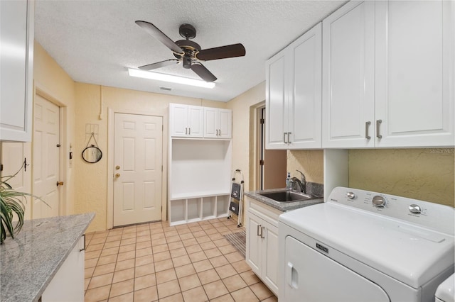 laundry area with sink, ceiling fan, cabinets, independent washer and dryer, and a textured ceiling