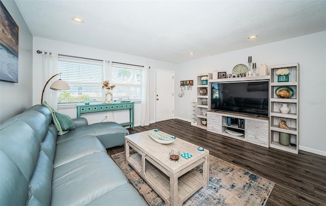 living room featuring dark wood-type flooring and a textured ceiling