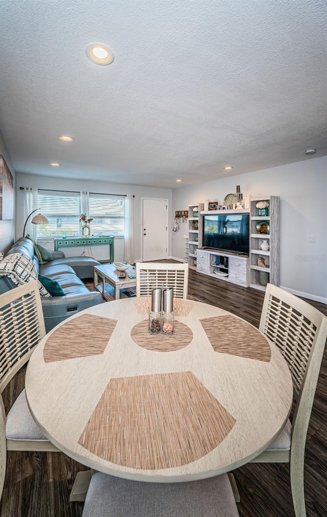 dining room featuring hardwood / wood-style flooring and a textured ceiling