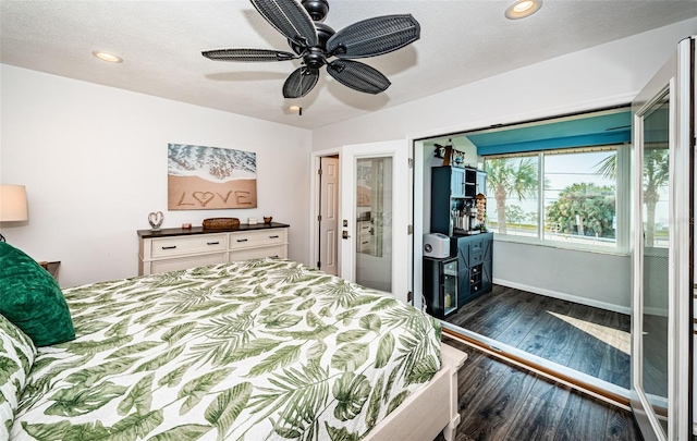 bedroom with dark hardwood / wood-style floors, a textured ceiling, and ceiling fan