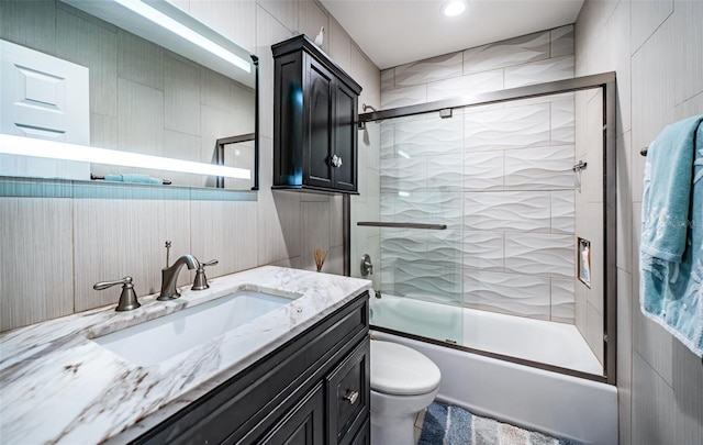 full bathroom with vanity, shower / bath combination with glass door, and toilet