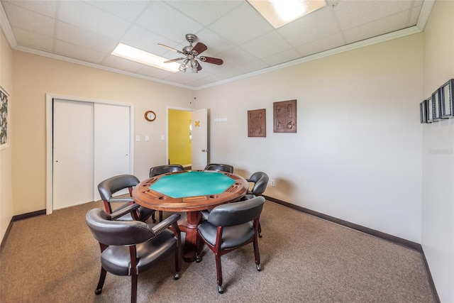 recreation room featuring crown molding, a paneled ceiling, ceiling fan, and carpet flooring