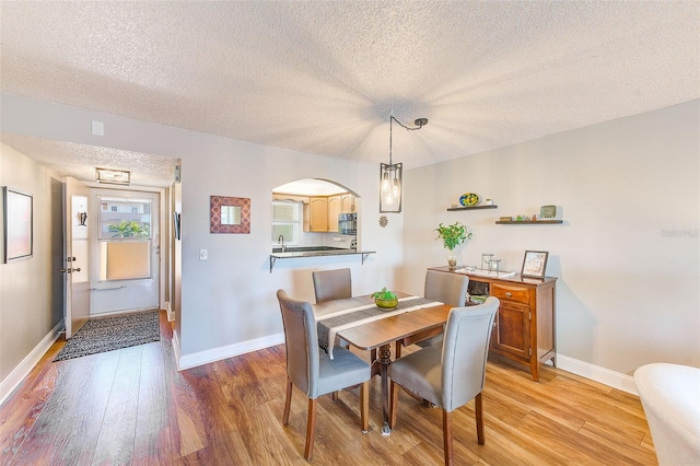 dining space featuring light hardwood / wood-style floors and a textured ceiling