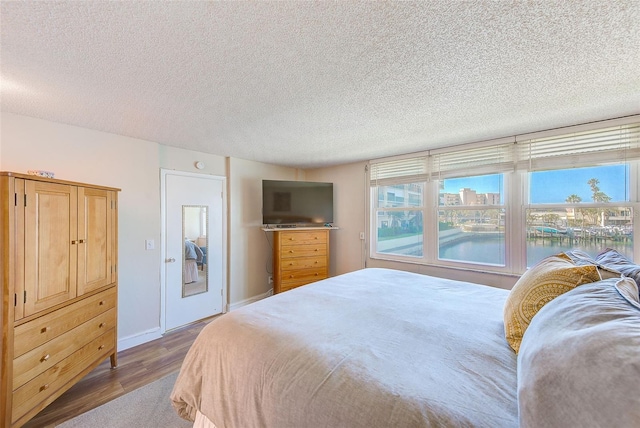 bedroom featuring hardwood / wood-style flooring and a textured ceiling