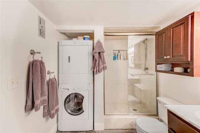 bathroom featuring walk in shower, stacked washer and clothes dryer, toilet, and vanity