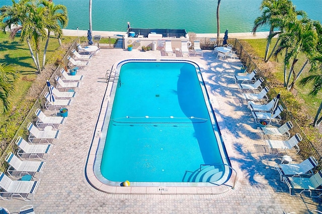 view of pool with a water view and a patio area