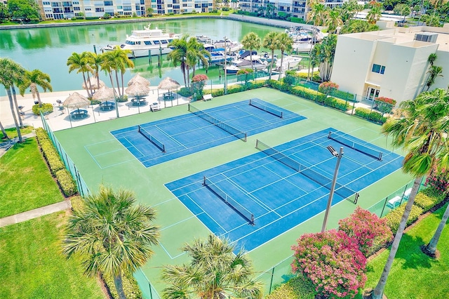 view of tennis court with a water view