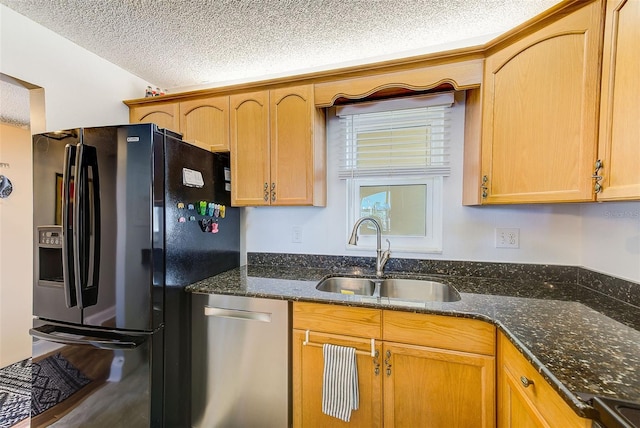 kitchen featuring black fridge, sink, stainless steel dishwasher, and a textured ceiling