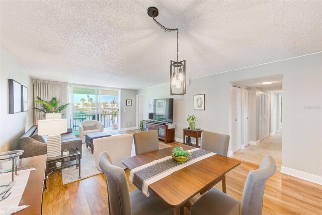 dining room featuring light hardwood / wood-style flooring and a textured ceiling