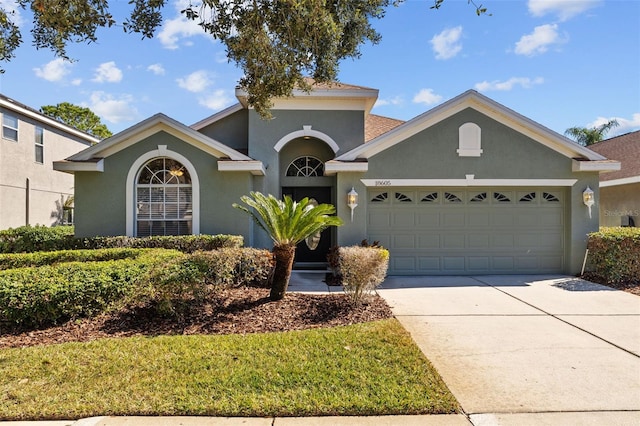 mediterranean / spanish-style home featuring a garage, concrete driveway, and stucco siding