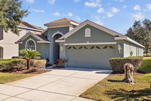 view of front of house featuring a garage, concrete driveway, and stucco siding